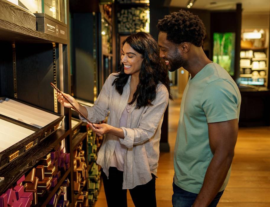 Visitantes interagindo com produtos na área de varinhas da Harry Potter New York