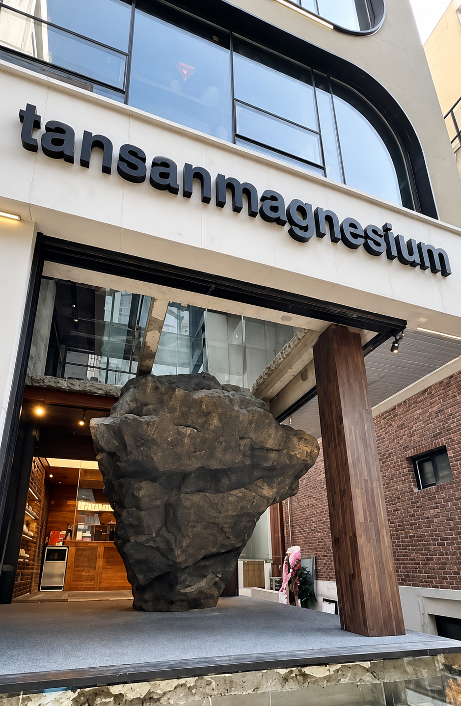 Interior da flagship Tansan Magnesium mostrando estrutura rochosa e arquitetura da loja
