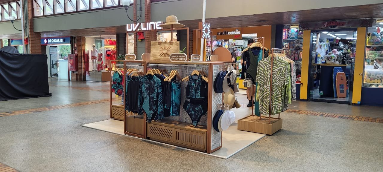 Quiosque de moda em formato compacto com exposição de roupas e acessórios
