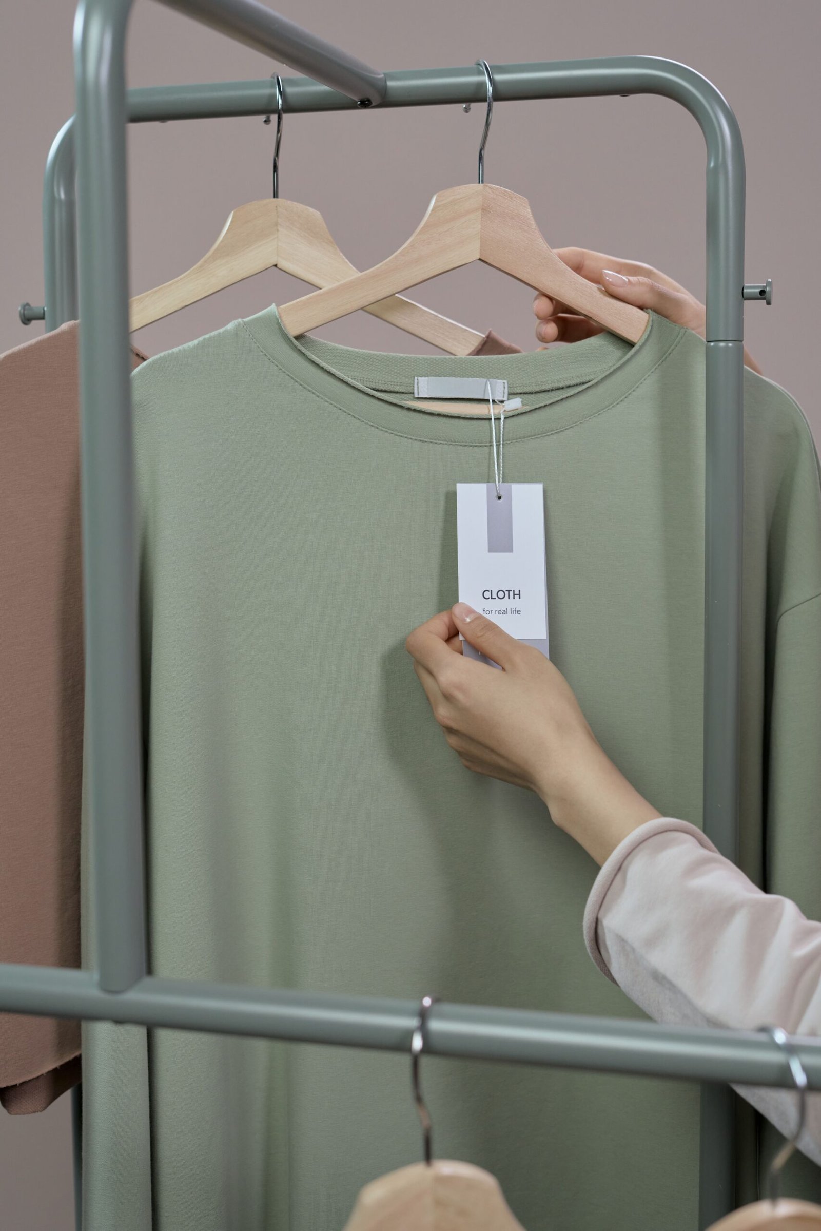 Pessoa analisando a etiqueta de uma peça de roupa em uma loja